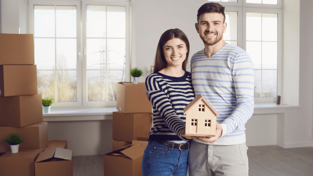 couple holding a miniature house