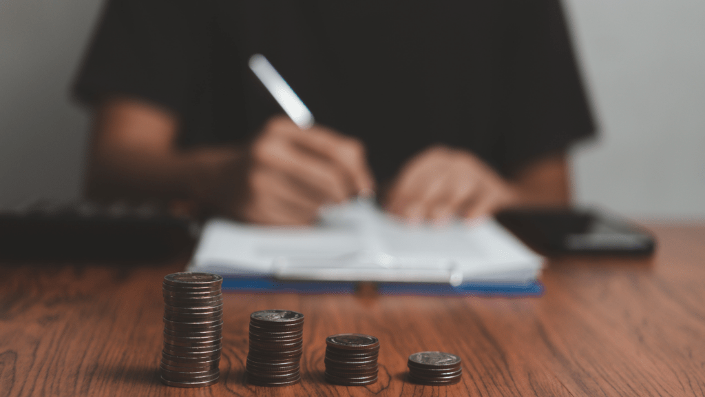 a person is placing coins on a table in front of a stack of coins