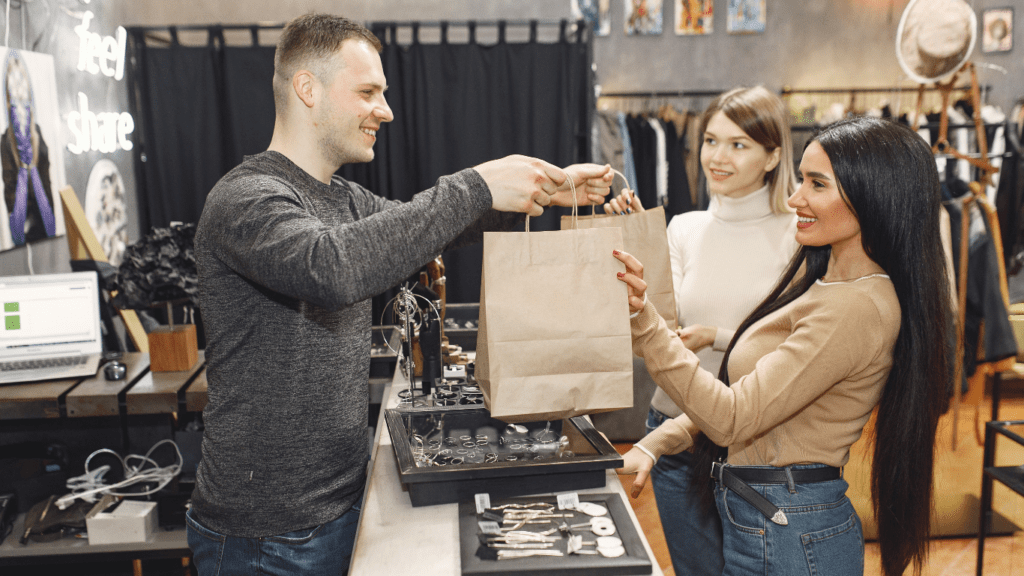 Two people are standing in front of a clothing store.