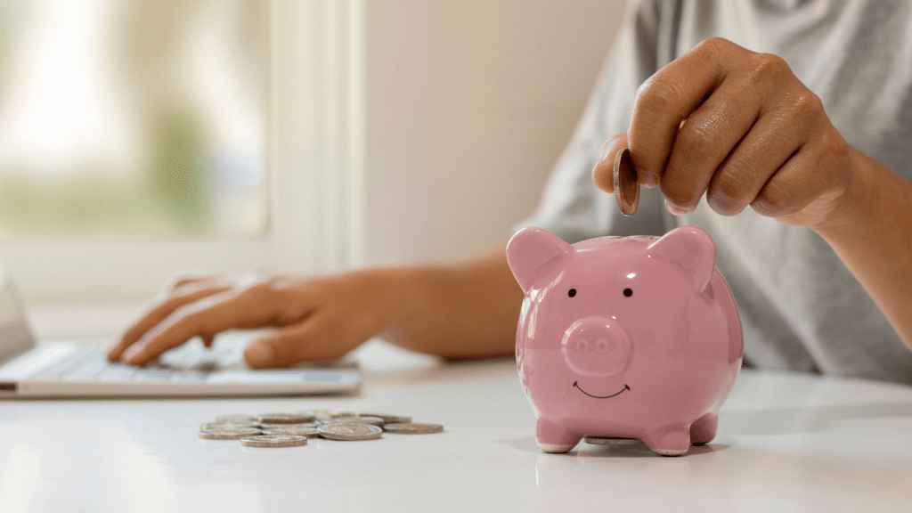 a person putting coins into a piggy bank