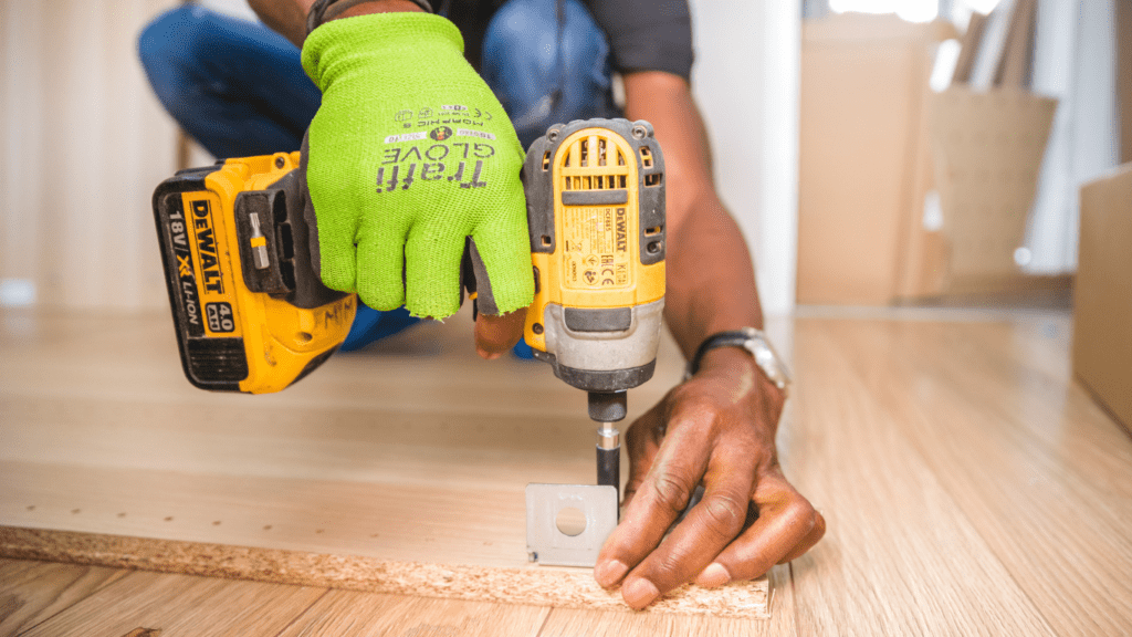 a person using a cordless drill on a wooden floor