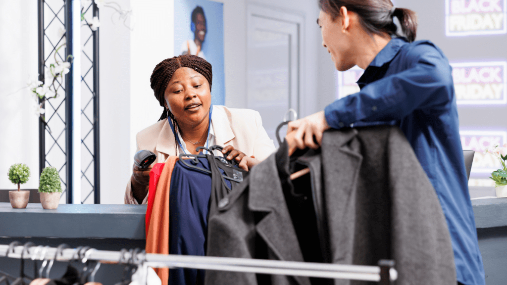 Two people are standing in front of a clothing store.