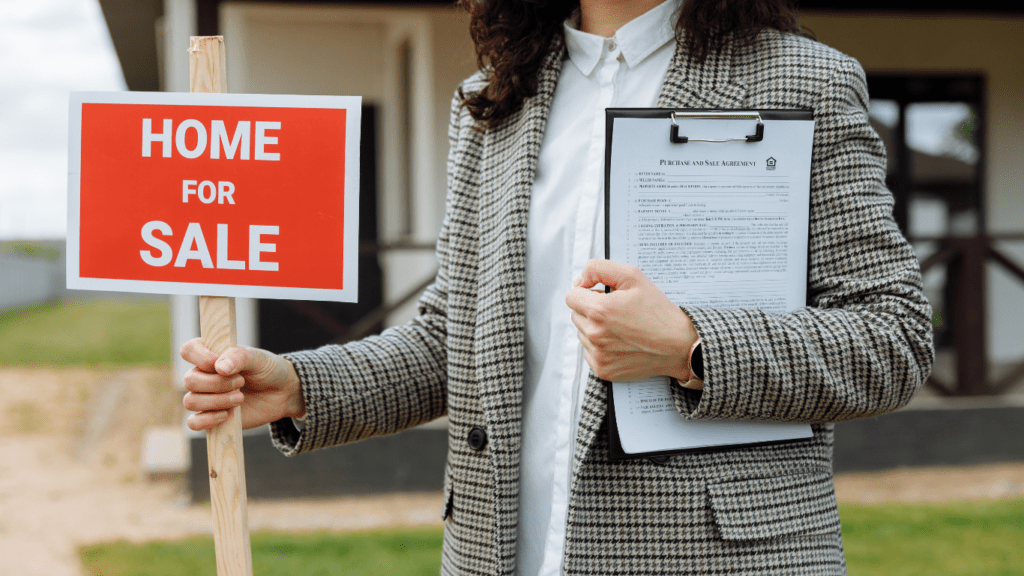 woman holding home for sale signage