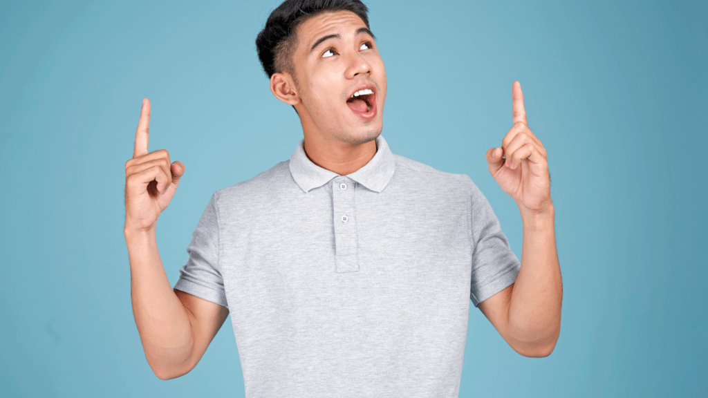 a person is pointing to something with both hands on a blue background