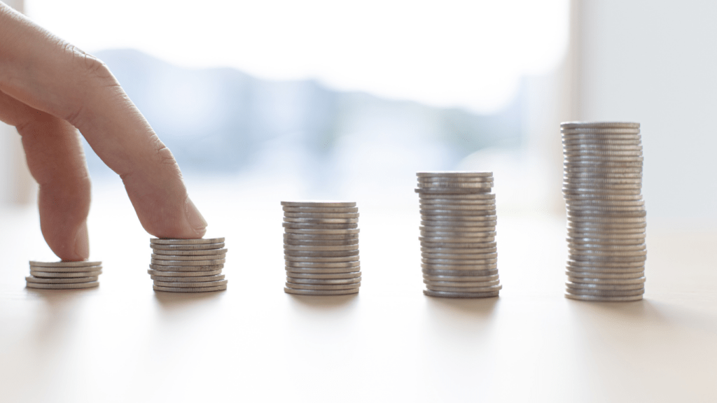 a person is placing coins on a table in front of a stack of coins