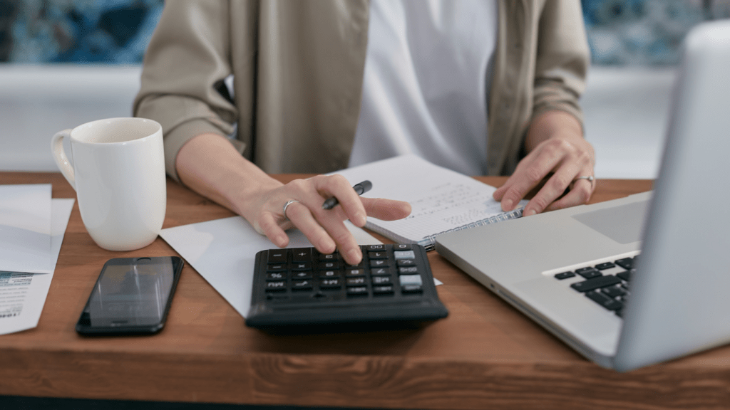 a person is using a calculator on a desk