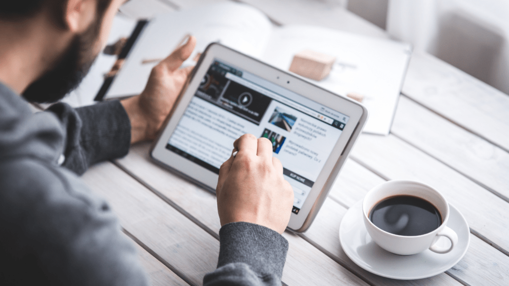 a person sits at a desk with a laptop and a cup of coffee