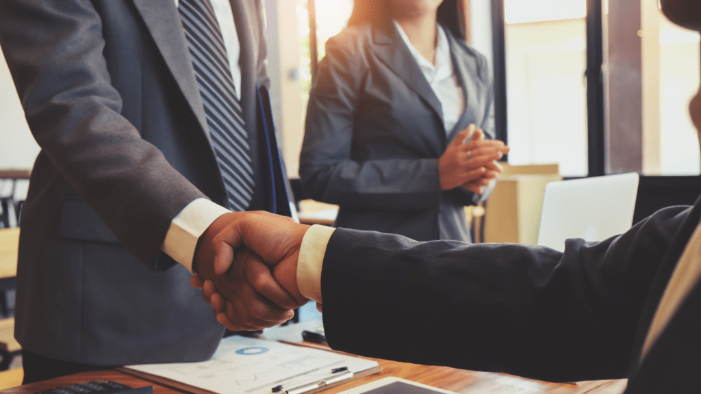 group of people shaking hands over a table