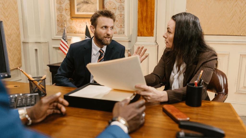 three people sitting at a table in an office