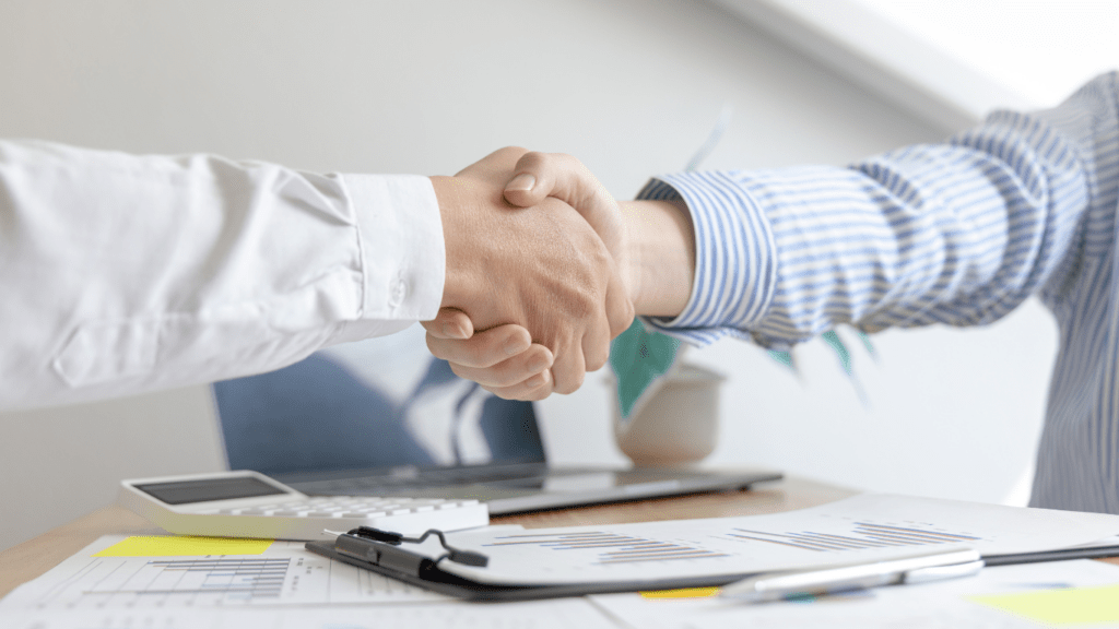 two business people shaking hands over a table